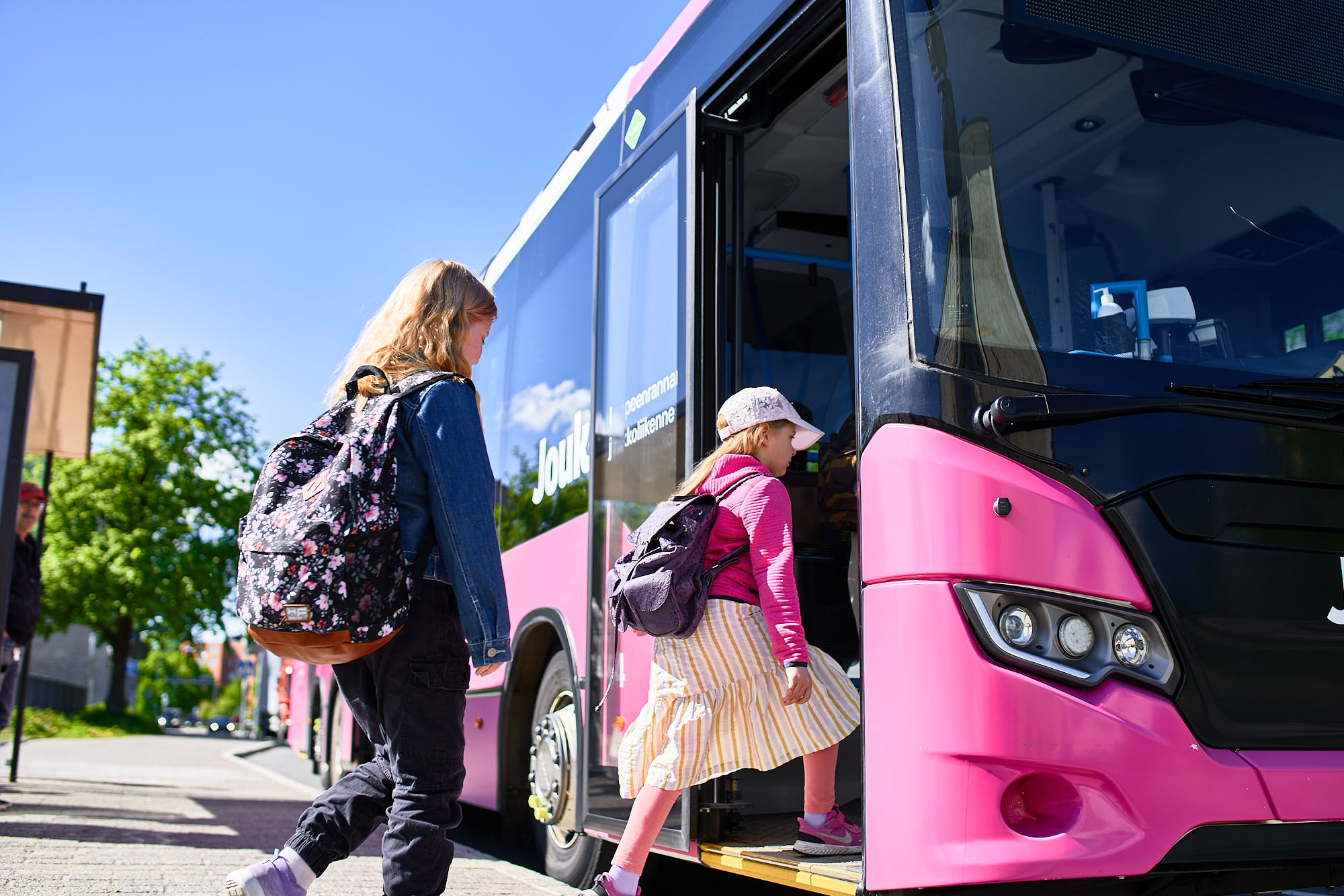 Kaksi lasta astuu sisään linja-autoon.